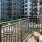 Alexandria VA Luxury Apartments with In Unit Washer and Dryer - Aventon Huntington Station - Balcony with Table and Chair Overlooking Expansive Community Courtyard, and Lush Landscaping