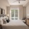 Pet Friendly Luxury Apartments in Alexandria VA- Aventon Huntington Station - Bedroom with Ceiling Fan, Bed, Two End Tables, Chair, Round Mirror, and Large Window